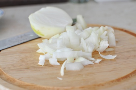 chopped onion on wooden chopping boardの写真素材