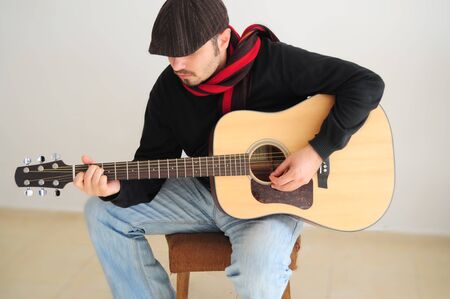 Young caucasian man playing the guitarの写真素材