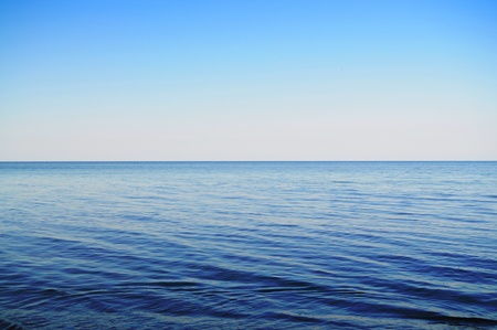 Calm sea extending to the horizon and clowdless skyの写真素材