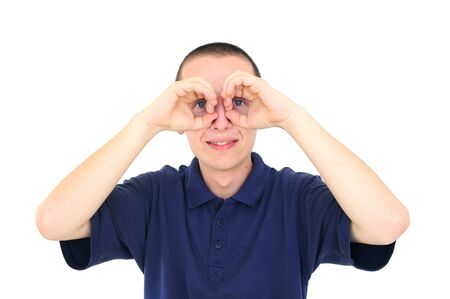 Young man looking through his fingers like binocularsの写真素材
