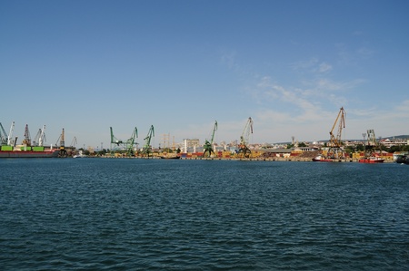 Overview of stacked containers and cranes at harbourの写真素材