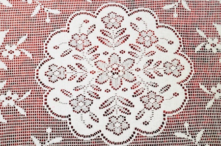 White handknitted lace over red velvetの写真素材