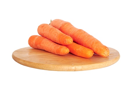 Bunch of fresh carrots on wooden board isolated on whiteの写真素材