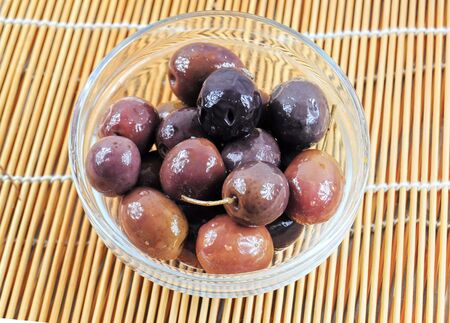 Fresh black olives in a glass bowlの写真素材