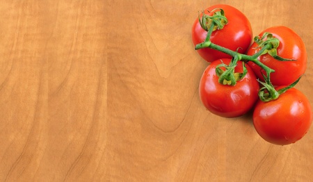 Branch of fresh tomatoes on wooden boardの写真素材