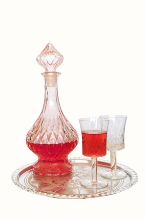 Vintage wine decanter and two glasses - one empty, one filled with red wine, on silver plateの写真素材