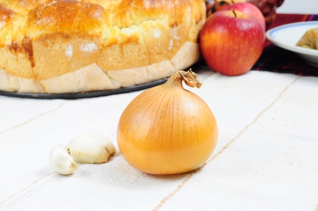 A single onion and three garlic cloves on traditionally arranged tableの写真素材