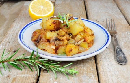Roasted potatoes and rosemary country style on wooden backgroundの写真素材