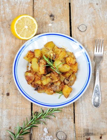 Roasted potatoes and rosemary country style on wooden backgroundの写真素材