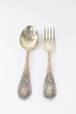 Vintage silver fork and spoon with ornaments on white backgroundの写真素材