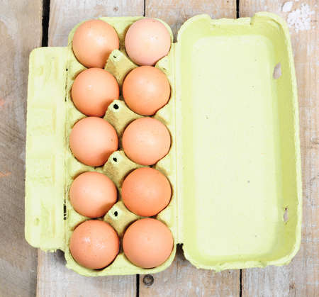 Carton of ten eggs on wooden backgroundの写真素材