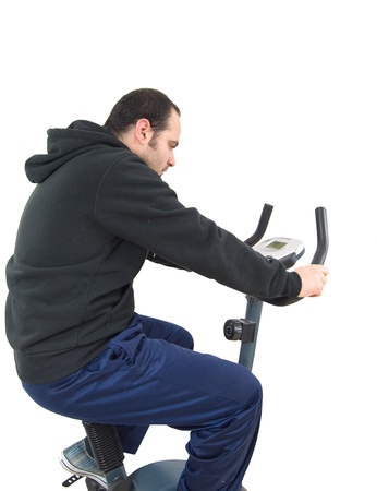 Young man on stationary exersice bike isolated on whiteの写真素材