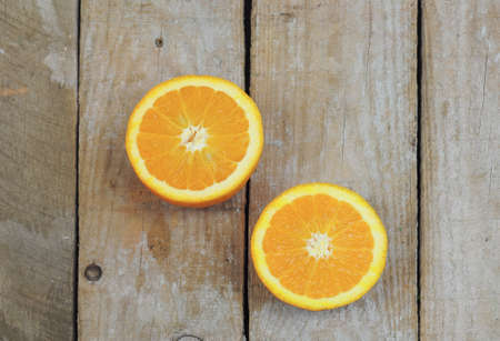 Fresh orange cut in half on wooden tableの写真素材