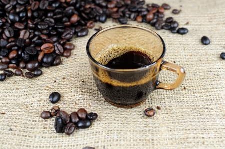 Coffee cup over scattered coffee beansの写真素材