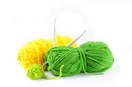 Green and yellow yarn and needles for knittingの写真素材