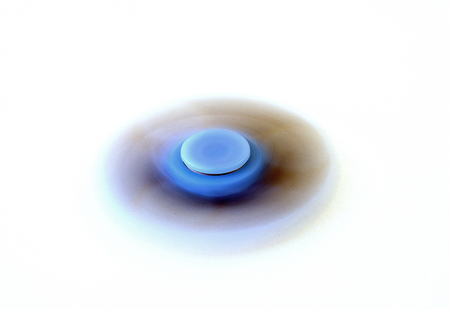 Blue fidget spinner spinning on white backgroundの写真素材