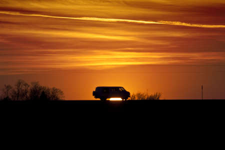 Van silhouetted against a sunsetの写真素材