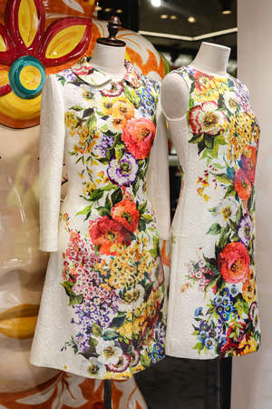 Italy, Verona 4.06.2014 Close-up of a shop window with two white mannequins. White coat and dress DOLCE & GABBANA made of fabric with a colorful bright pattern with beautiful colors of red, yellow,D&Gのeditorial素材