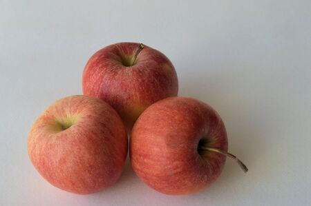 Apples. On a white background three apples. Apples juicy and rosy red.の写真素材