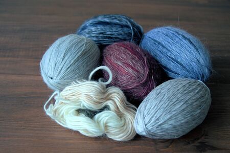 Yarn. On a wooden background are multicolored balls of wool yarn. Balls of yarn for knitting.の写真素材