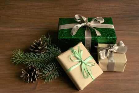 Christmas. On a brown wooden coat tree branch. Around three boxes with Christmas gifts. Boxes...