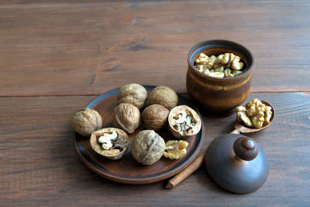Walnuts. Walnuts on a wooden plate. Kernels purified in a wooden bowl. Wooden spoon with kernels of...