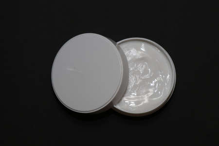 Jade roller, together with a cream to moisturize the skin and smooth out wrinkles on a black backgroundの写真素材