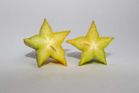 A small and juicy carambola isolated on a white background. Delicious and healthy yellow fruit