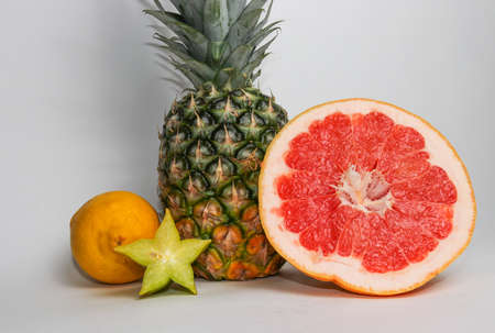 Still life of pineapple, lemon, carambola and grapefruit isolated on whiteの写真素材