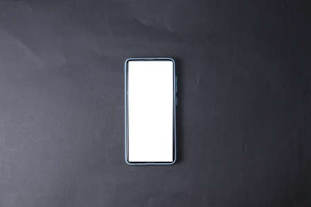 The phone is isolated on a black background. A smartphone with a white screenの写真素材