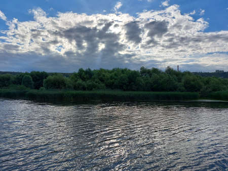 View from the middle of the river to the hilly banks overgrown with forest