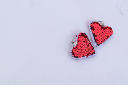 Two red hearts in the snow. Close-up.