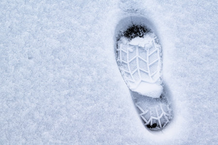 Footprint of shoes on ice covered with snowの写真素材