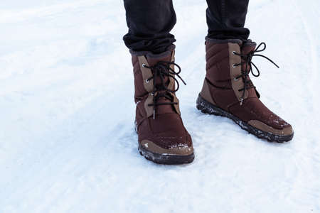 Winter brown men's boots on the snow.の写真素材