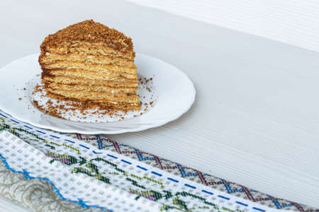 A slice of honey cake on a white plateの写真素材