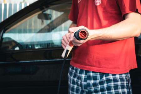 Car wash. A man holds a Karcher sink in his hands. Close-upの写真素材