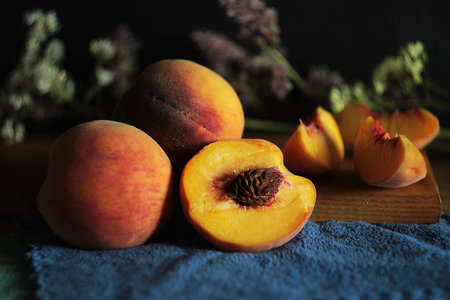 Ripe peaks on a wooden board on a dark background.の写真素材