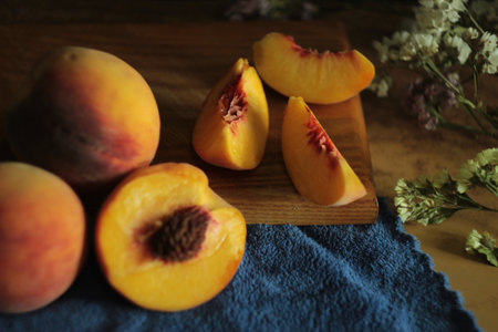 Ripe peaches on a wooden board and blue napkin.
