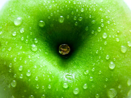 Closeup shot of wet green apple with a stalkの写真素材