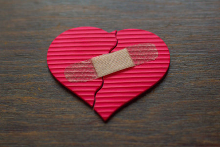 Heart broken with adhesive bandage on wooden background. Health care conceptの写真素材