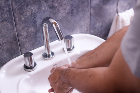 Man washing his hands with neutral soap and water - rinse