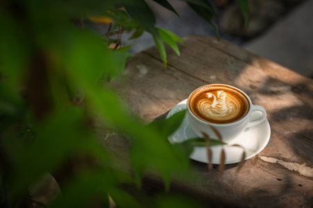 A cup of coffee with latte art on wooden table in coffee shopの写真素材