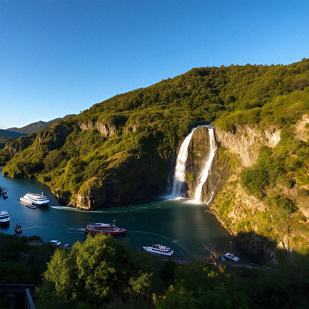 Aerial view of a waterfall in the middle of a river with boats on the waterの素材