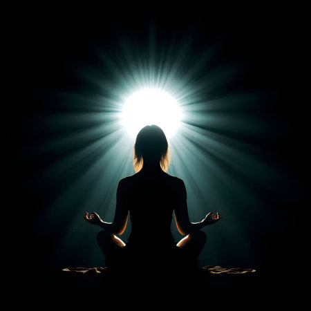 Woman meditating in lotus pose on dark background with light raysの素材