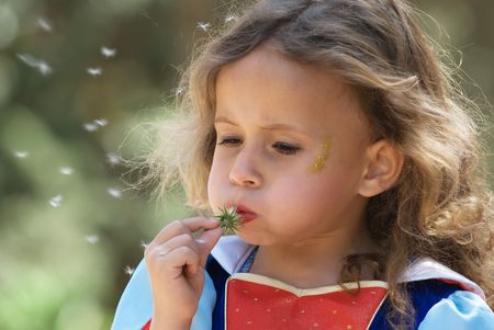 Girl blowing dandelionの写真素材