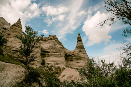 Unique rock formations and eroded cliffs against blue sky with white clouds