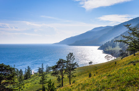 Landscape of blue lake deep in the light of the sun in the daytime, clouds in the sky
