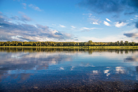 Landscape of blue lake deep in the light of the sun in the daytime, clouds in the sky