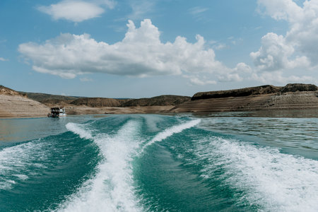 Landscape of blue lake deep in the light of the sun in the daytime, clouds in the skyの写真素材