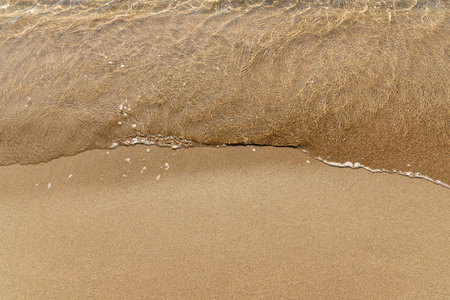 Sandy yellow beach with sea background, wave ocean in sandの写真素材